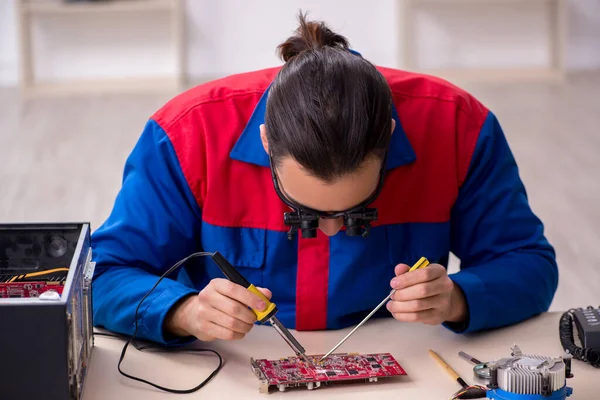 Молодой ремонтник-мужчина ремонтирует компьютер — стоковое фото