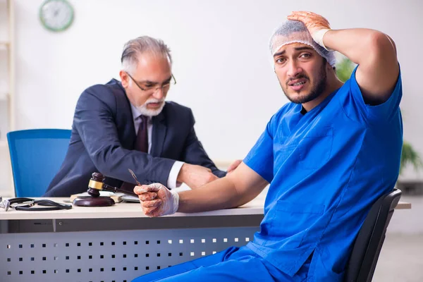 Male doctor in courthouse meeting with advocate