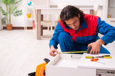 Genç erkek marangoz içeride çalışıyor.