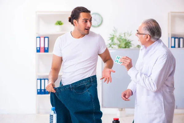 Doctor dietician and happy patient wearing large trousers — Stok fotoğraf