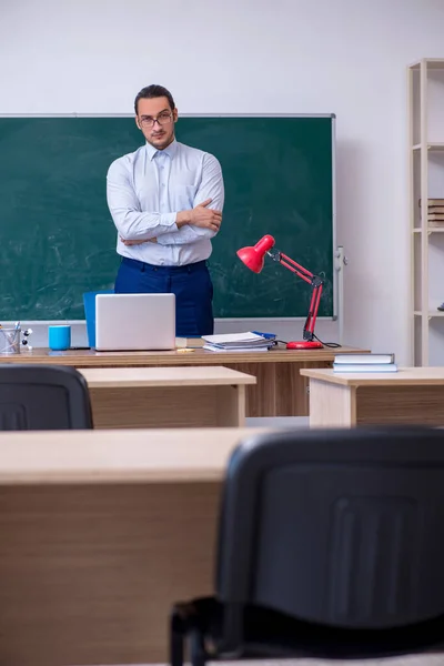 Jonge mannelijke leraar in de voorkant van groene boord — Stockfoto