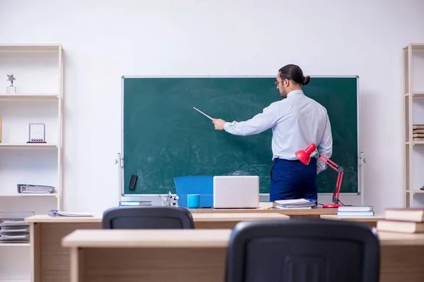 Junger männlicher Lehrer vor grünem Brett — Stockfoto