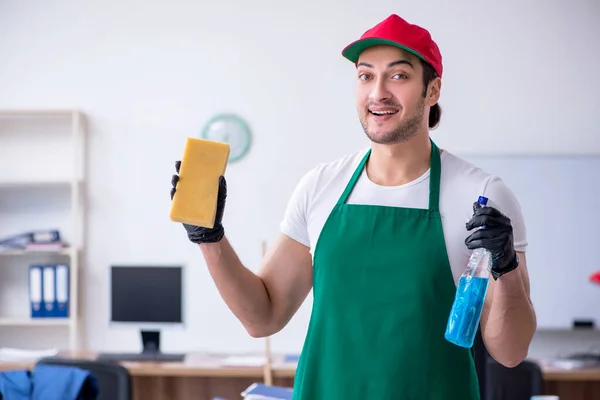 Joven contratista masculino limpiando la oficina —  Fotos de Stock