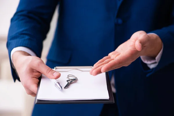 Knappe mannelijke makelaar die binnen werkt — Stockfoto