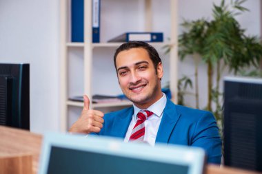 Ofiste çalışan genç bir erkek.