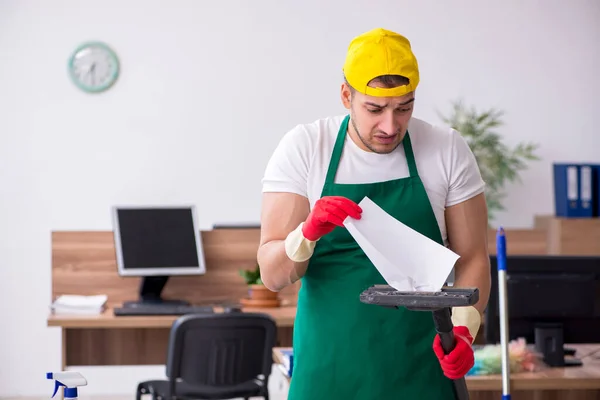 Jovem empreiteiro limpando o escritório — Fotografia de Stock