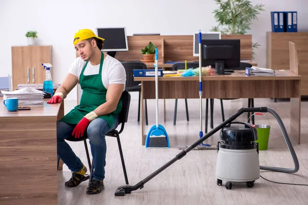 Jonge mannelijke aannemer schoonmaken van het kantoor — Stockfoto