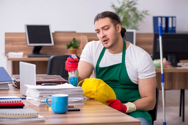 事務所を掃除する若い男の請負業者 — ストック写真