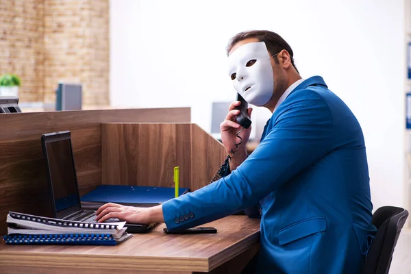 Mladý muž zaměstnanec nosí masku v kanceláři — Stock fotografie