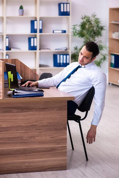 Young male employee unhappy with excessive work in the office — Stock Photo, Image