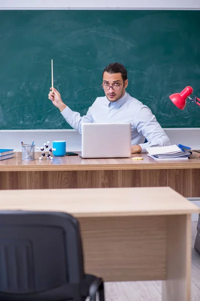 Jonge mannelijke leraar in de voorkant van groene boord — Stockfoto