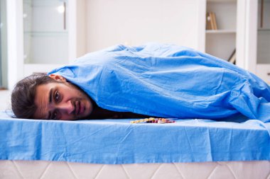 Evde acı çeken genç hasta adam.