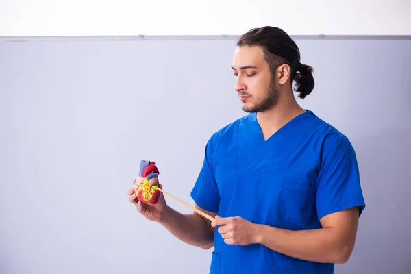 Jonge mannelijke arts leraar cardioloog in de voorkant van whiteboard — Stockfoto