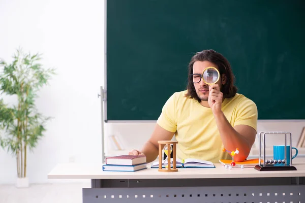 Jonge mannelijke student natuurkundige voorbereiding voor examens in de klas — Stockfoto