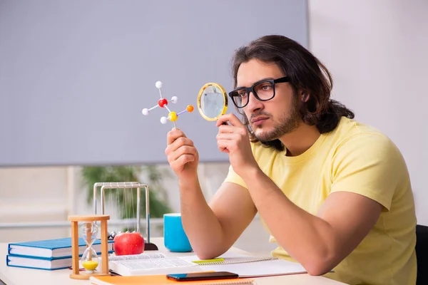 Jonge mannelijke student natuurkundige voorbereiding voor examens in de klas — Stockfoto