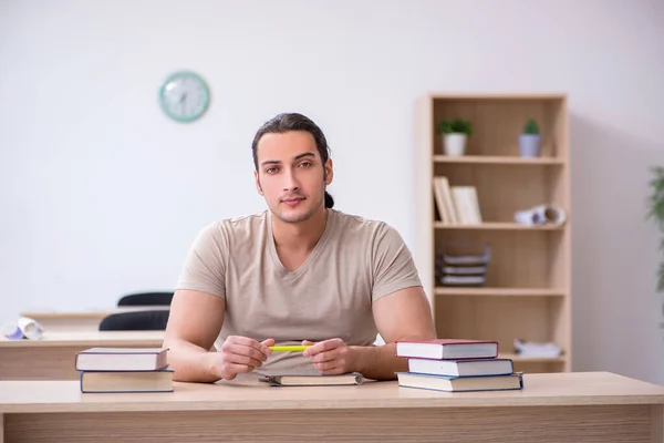 Jovem estudante se preparando para exames na biblioteca — Fotografia de Stock