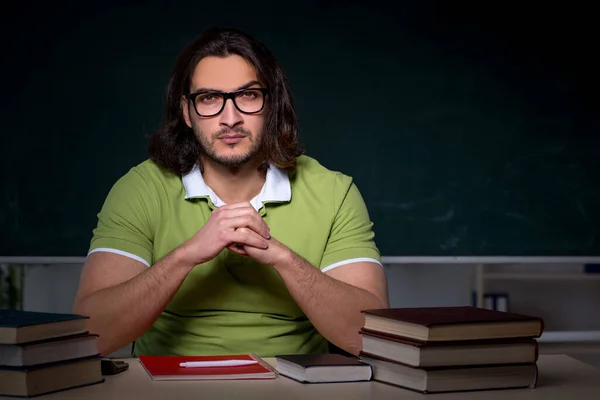 Ung manlig student förbereder sig för tentor i klassrummet — Stockfoto