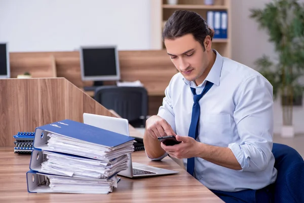 Giovane dipendente maschio infelice con il lavoro eccessivo — Foto Stock