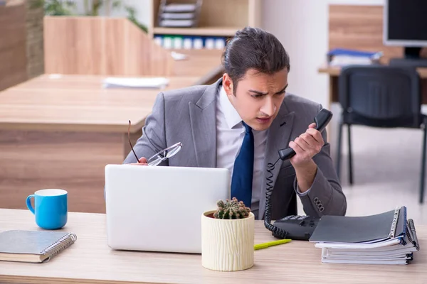 Jonge mannelijke werknemer werkzaam in het kantoor — Stockfoto