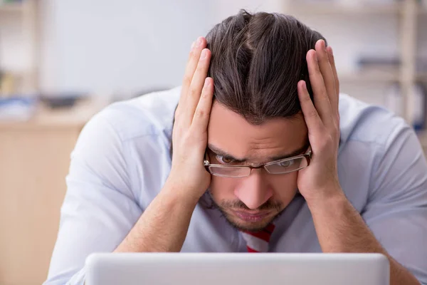 Young male employee unhappy with excessive work — Stock Photo, Image