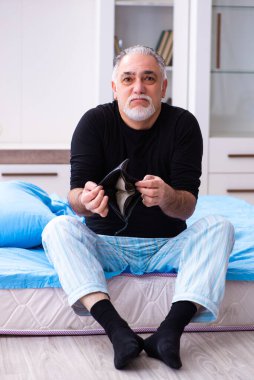 Yaşlı adamın yatak odasında parası bitiyor.