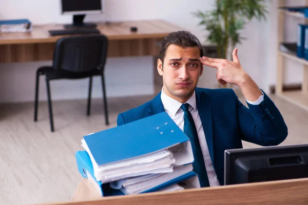 Ofisteki aşırı işten memnun olmayan genç bir erkek işçi. — Stok fotoğraf