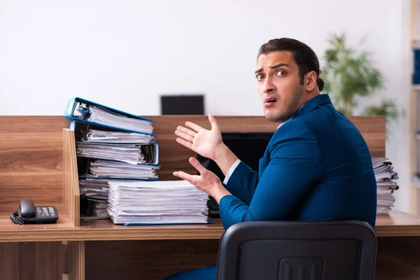 Junge männliche Angestellte unzufrieden mit exzessiver Arbeit im Büro — Stockfoto