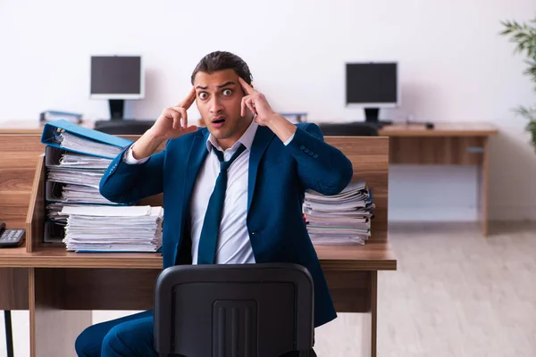 Joven empleado masculino descontento con el trabajo excesivo en la oficina — Foto de Stock