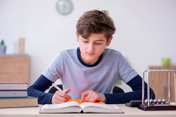 Écolier étudiant la physique à la maison — Photo