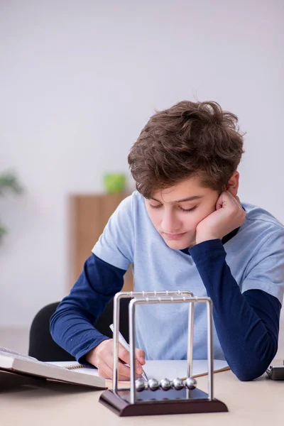 Écolier étudiant la physique à la maison — Photo