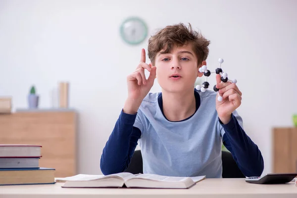 Schoolboy olhando para modelo molecular em casa — Fotografia de Stock