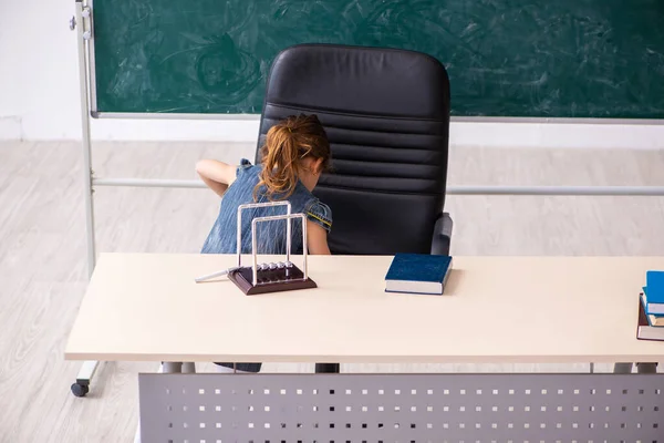 Broma de la escuela secundaria con pinzas afiladas en la silla —  Fotos de Stock