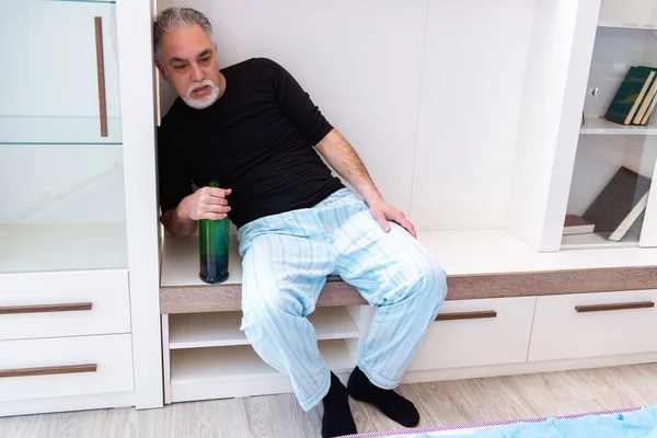 Old man drinking wine in the bedroom — Stock Photo, Image