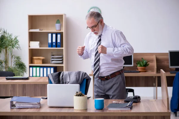 Vecchio dipendente maschio affetto da radicolite sul posto di lavoro — Foto Stock