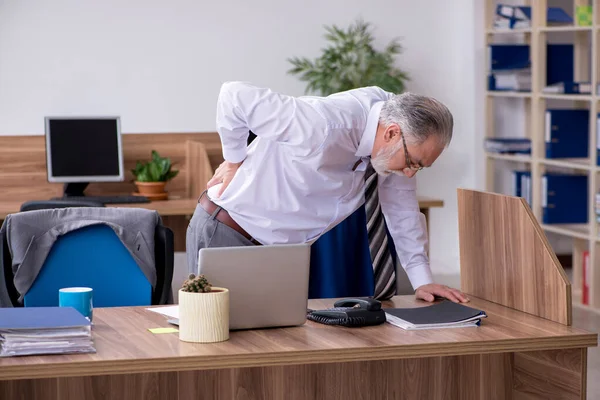 Alter männlicher Mitarbeiter leidet an Radikulitis am Arbeitsplatz — Stockfoto