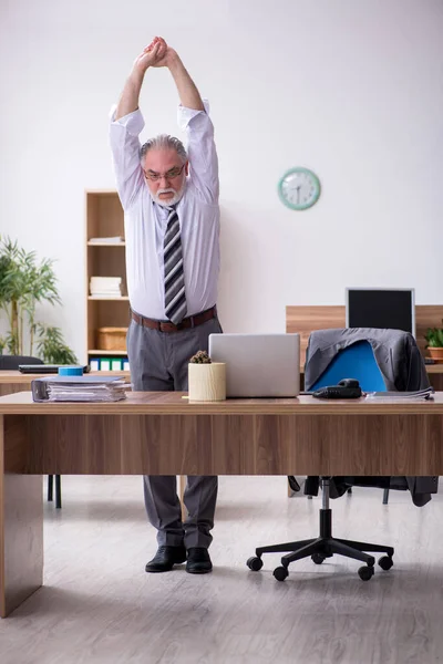 Velho trabalhador masculino que sofre de radiculite no local de trabalho — Fotografia de Stock