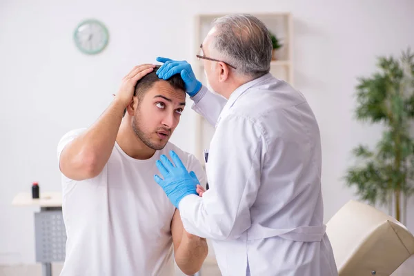 Giovane uomo in visita medico dermatologo esperto — Foto Stock