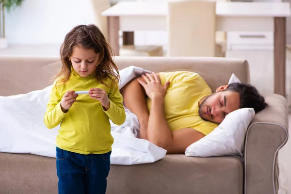 Menina pequena cuidando de seu pai doente — Fotografia de Stock