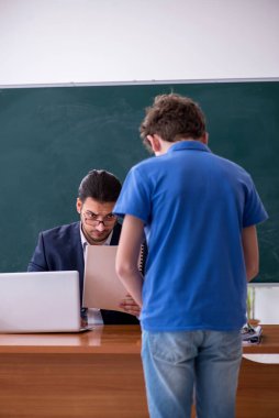 Genç erkek öğretmen ve okul çocuğu sınıfta.