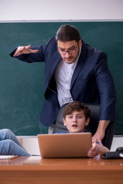 Genç erkek öğretmen ve okul çocuğu sınıfta.