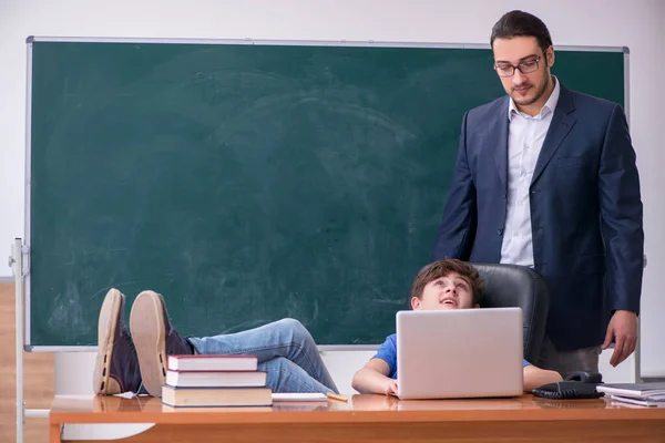 Jeune enseignant et écolier dans la salle de classe — Photo