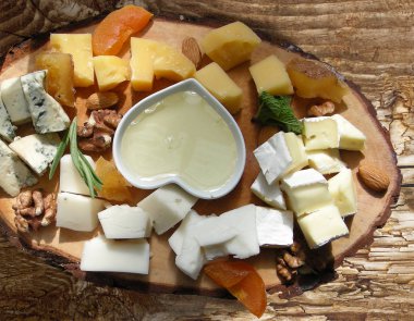 Peynir, bal, badem, Kuru kayısı ve ceviz ahşap tahta üzerinde çeşitli peynir tabağı