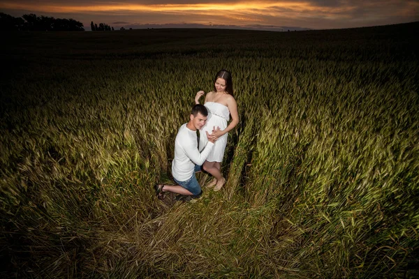 young parents in the evening on a wheat field