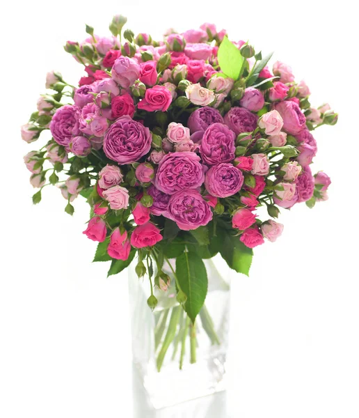 Beyaz arka plan üzerinde izole cam vazoda pembe ve mor gül buketi