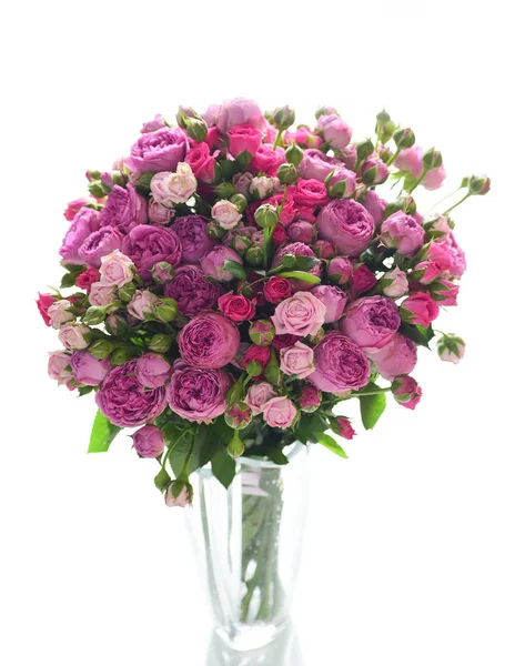 Beyaz arka plan üzerinde izole cam vazoda pembe ve mor gül buketi