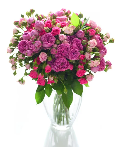 Beyaz arka plan üzerinde izole cam vazoda pembe ve mor gül buketi
