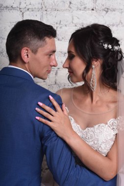 Gelin ve damat tuğla duvar arka plan üzerinde poz portresi