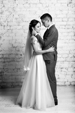 Yeni evliler Studio tuğla duvar zemin üzerine sarılma görünümünü tam uzunlukta