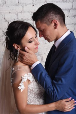 Tuğla duvar arka plan üzerinde poz güzel yeni evliler portresi