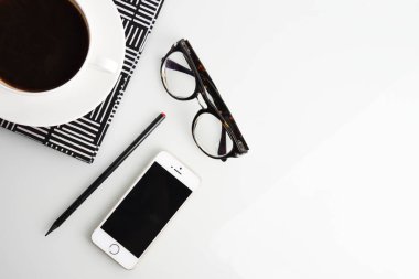Kahve fincanı, kalem, smartphone, gözlük ve çizgili Not defteri ile Ofis İşyeri